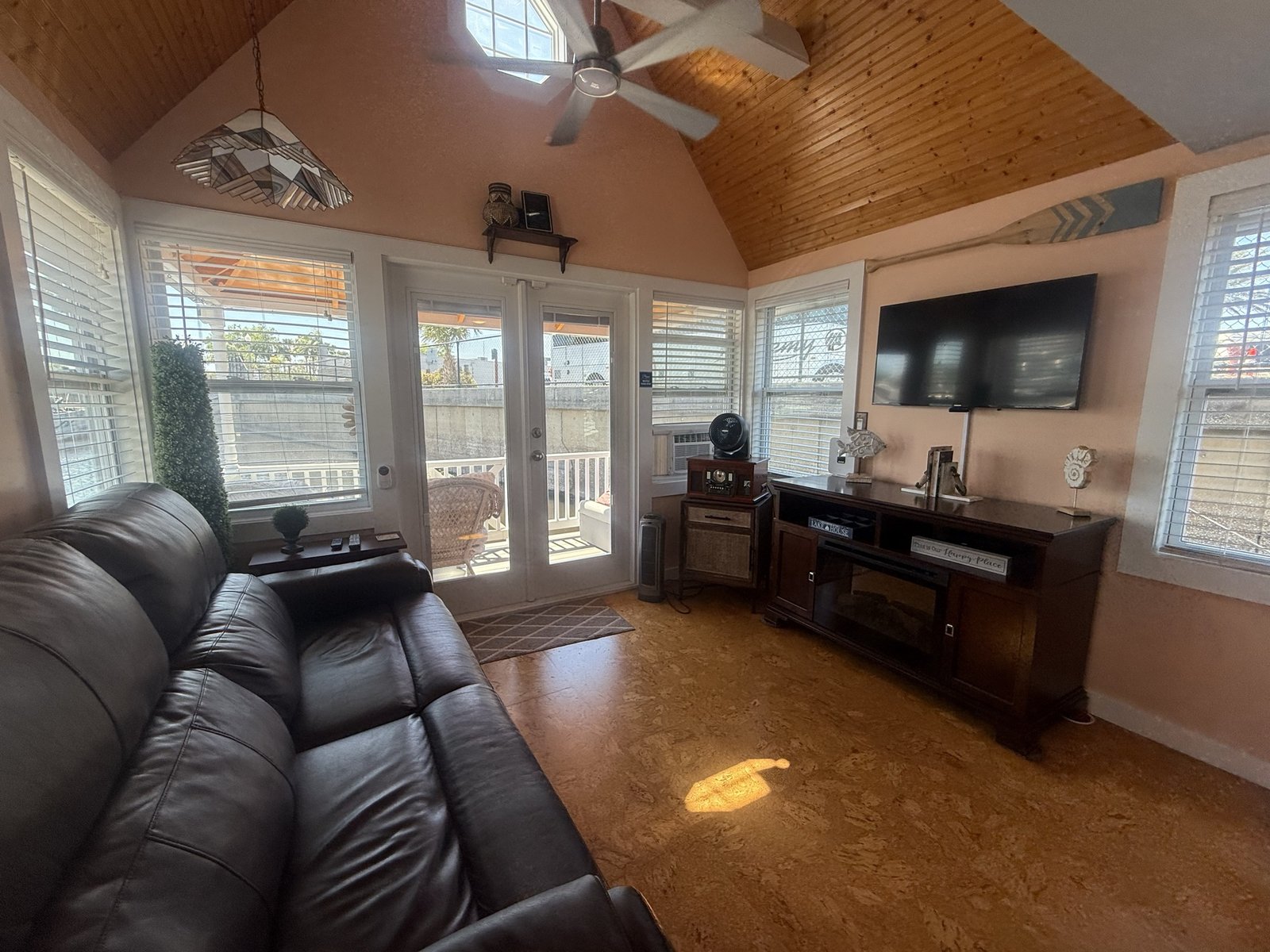 Bright living room with a vaulted wood ceiling and porch access